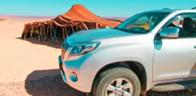 A picture of grey 4x4 toyota visiting Merzouga nomads tent