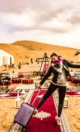 A pictures of a girl holding her bag in a luxury desert camp