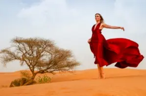 A women in the desert with a red dress