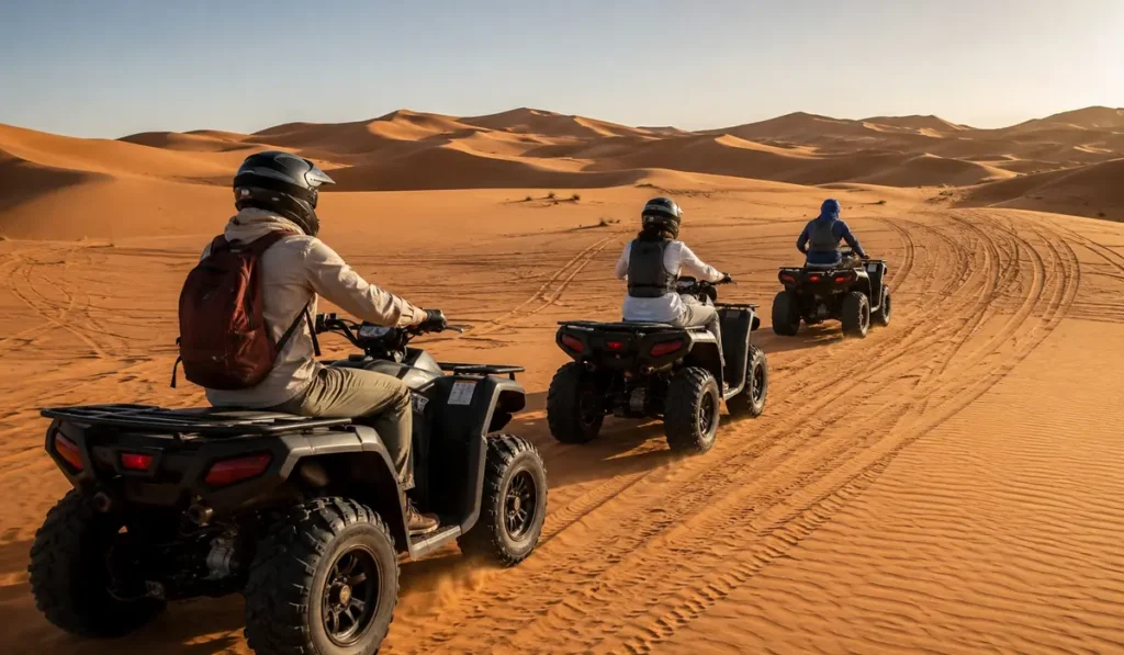 Travelers following a local guide on quad bikes across the Erg Chebbi dunes in Merzouga